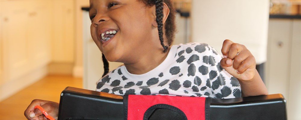 A young disabled girl in smiling in her powered wheelchair