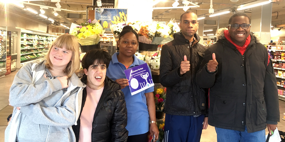 Group of young people with member of Co-op staff in store
