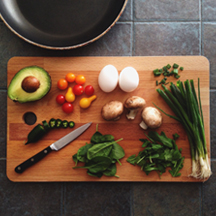 a chopping board with ingredients and a sharp knife on it