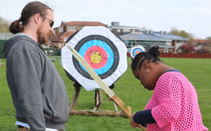 Girl with Down Syndrome learning archery