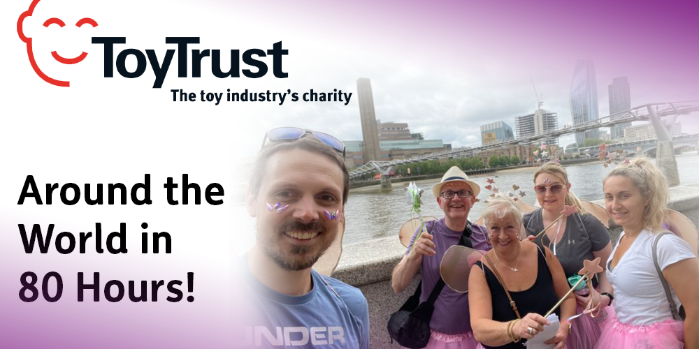 Group of toy industry members by the river Thames, with the Toy Trust logo in the top left corner